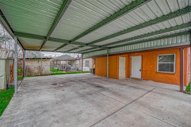 garage featuring a carport and fence