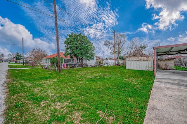 view of yard featuring an outdoor structure and driveway