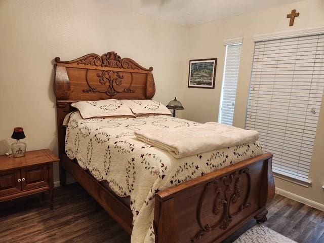 bedroom with dark wood finished floors and baseboards