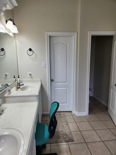 full bath featuring tile patterned floors, double vanity, toilet, and baseboards