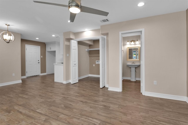 unfurnished bedroom with wood finished floors, baseboards, and recessed lighting
