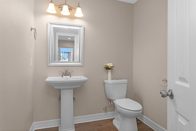 bathroom featuring toilet, baseboards, and wood finished floors