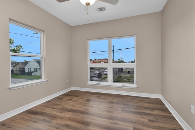 spare room featuring wood finished floors, a ceiling fan, and baseboards