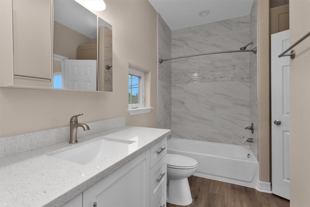 bathroom with toilet,  shower combination, vanity, and wood finished floors