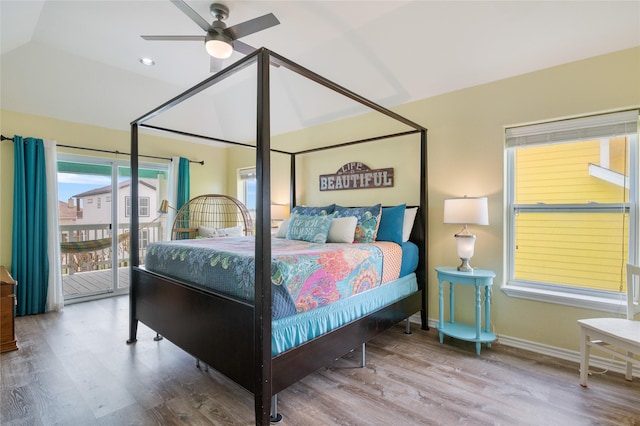 bedroom featuring wood finished floors, access to outside, vaulted ceiling, baseboards, and a ceiling fan