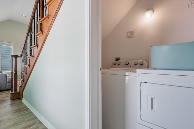 clothes washing area featuring separate washer and dryer, light wood-style flooring, baseboards, and recessed lighting