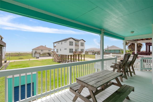 wooden terrace featuring a lawn and a residential view