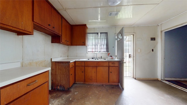 415 Briarcliff Dr, Houston, TX 77076 - kitchen with a sink, concrete floors, brown cabinetry, and light countertops