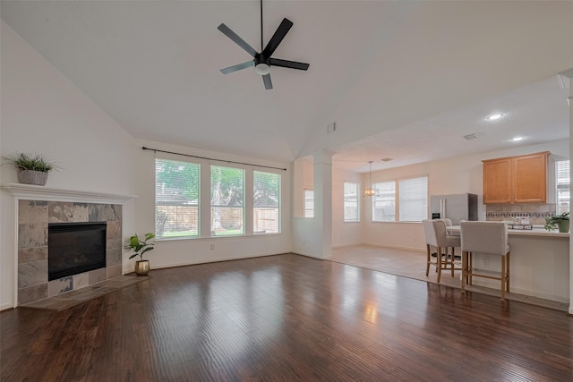 unfurnished living room with ceiling fan, plenty of natural light, a fireplace, wood finished floors, and recessed lighting
