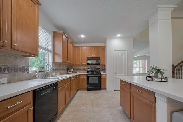 kitchen with black appliances, a sink, plenty of natural light, light countertops, and recessed lighting