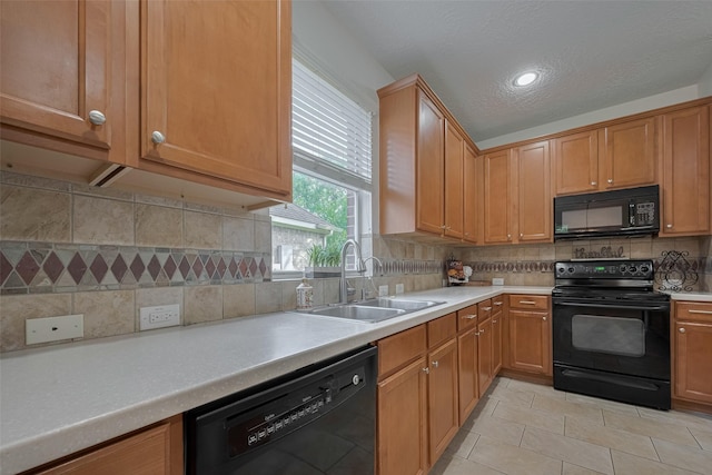 kitchen featuring black appliances, a sink, light countertops, backsplash, and a textured ceiling
