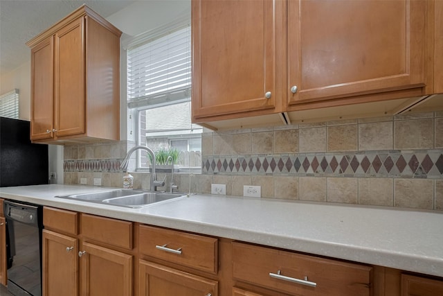 kitchen featuring a sink, dishwasher, light countertops, and tasteful backsplash