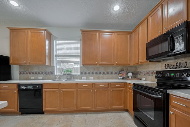 kitchen with black appliances, a sink, light countertops, a textured ceiling, and decorative backsplash