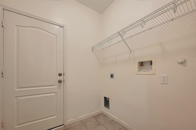 clothes washing area featuring hookup for an electric dryer, hookup for a washing machine, baseboards, and light tile patterned flooring