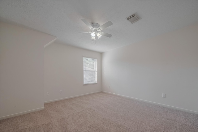 empty room with ceiling fan, light carpet, a textured ceiling, and baseboards