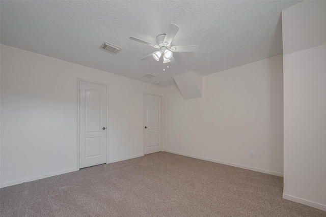 spare room featuring carpet, ceiling fan, a textured ceiling, and baseboards