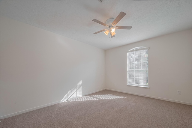 empty room with ceiling fan, carpet floors, baseboards, and a textured ceiling