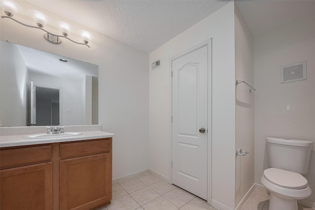 bathroom with tile patterned floors, vanity, toilet, a textured ceiling, and baseboards