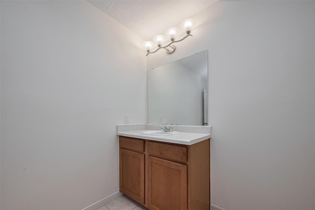 bathroom with vanity, tile patterned flooring, a textured ceiling, and baseboards