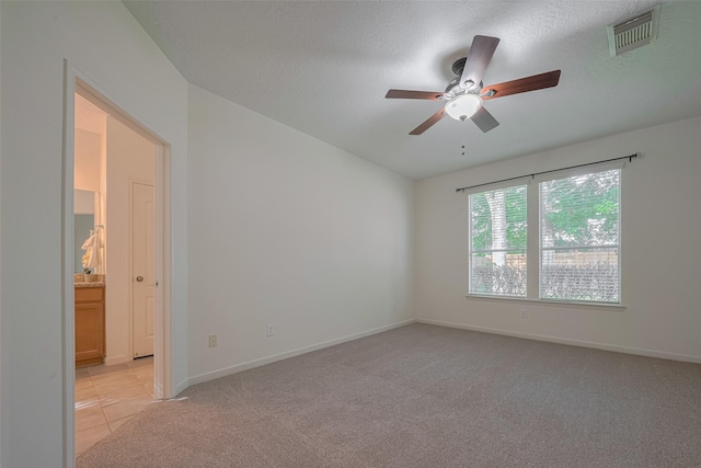 unfurnished room featuring ceiling fan, light carpet, baseboards, and a textured ceiling
