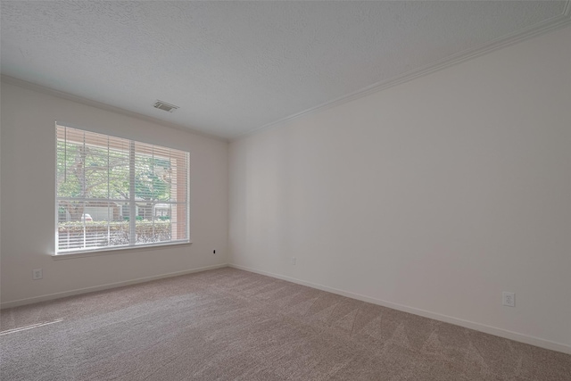carpeted spare room with ornamental molding, a textured ceiling, and baseboards