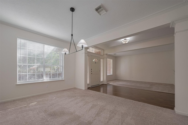 unfurnished dining area featuring carpet, ornamental molding, baseboards, a chandelier, and a textured ceiling