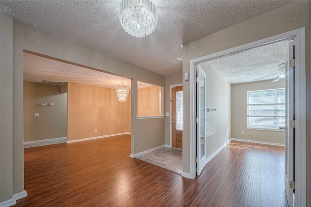 194 Velvet Leaf Pl, The Woodlands, TX 77380 - spare room with a chandelier, a textured ceiling, wood finished floors, and baseboards