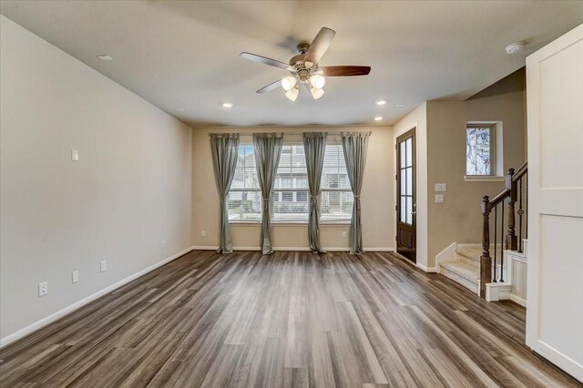 9438 Caddo Ridge Ln, Cypress, TX 77433 - unfurnished living room featuring a ceiling fan, wood finished floors, stairway, baseboards, and recessed lighting