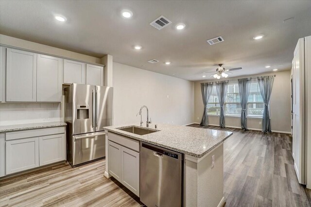 9438 Caddo Ridge Ln, Cypress, TX 77433 - kitchen with stainless steel appliances, a sink, light wood-style flooring, ceiling fan, and recessed lighting