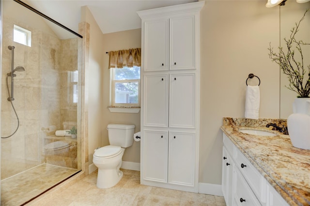 bathroom featuring tiled shower, vanity, toilet, and baseboards
