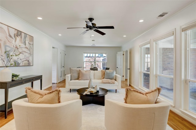 living room featuring ornamental molding, light wood finished floors, recessed lighting, and a ceiling fan