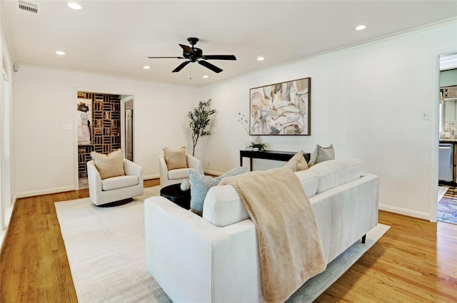 living room featuring crown molding, ceiling fan, recessed lighting, light wood-style floors, and baseboards