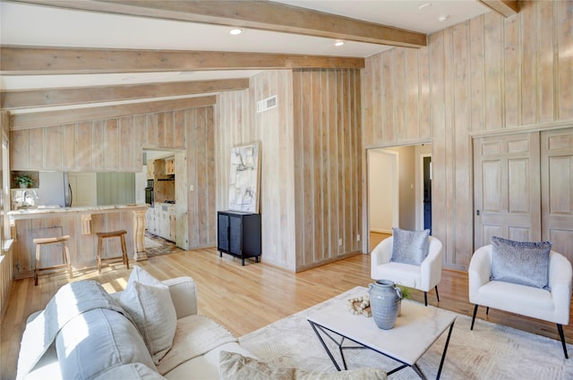 living area featuring light wood-style flooring and wood walls