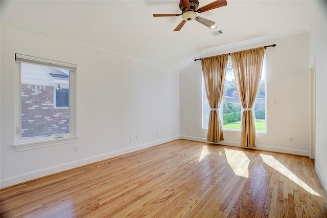 unfurnished room with crown molding, light wood-style flooring, baseboards, ceiling fan, and vaulted ceiling