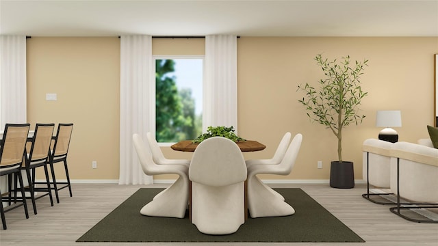 dining space featuring light wood-style flooring and baseboards