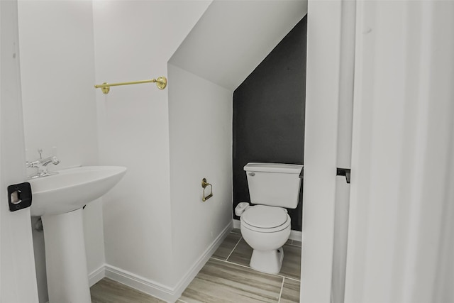 8888 Benning Dr Unit 313, Houston, TX 77031 - bathroom with toilet, wood finished floors, baseboards, and lofted ceiling
