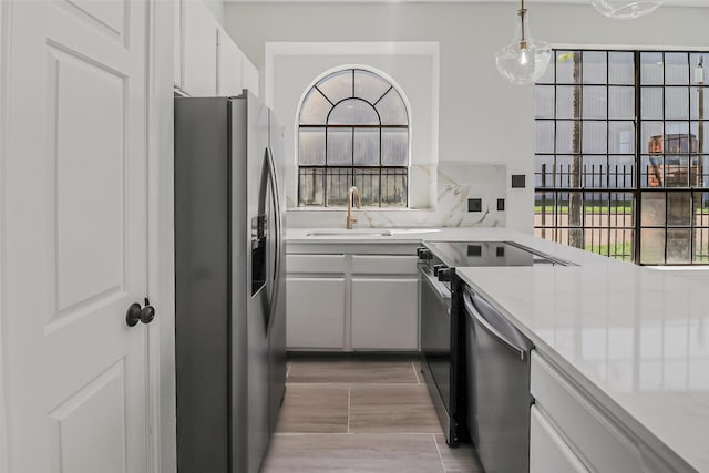 8888 Benning Dr Unit 313, Houston, TX 77031 - kitchen with appliances with stainless steel finishes, a sink, light countertops, and hanging light fixtures