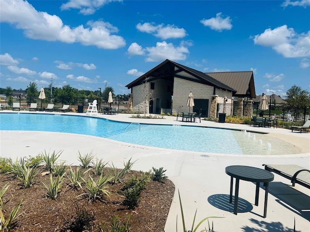 community pool with fence and a patio