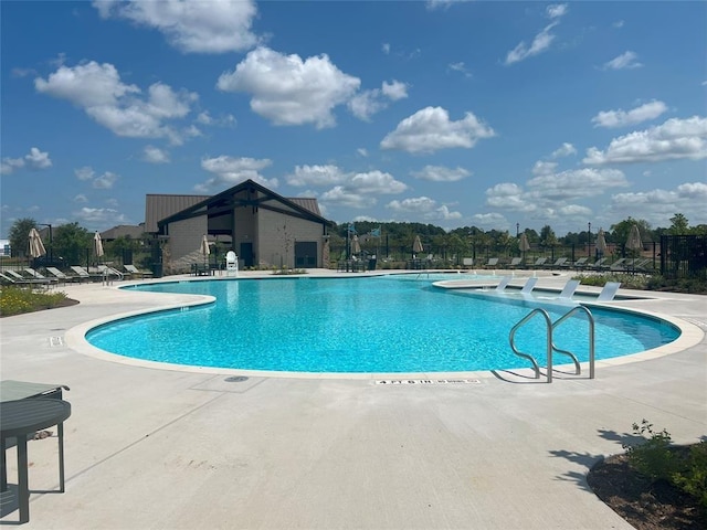 community pool featuring a patio and fence