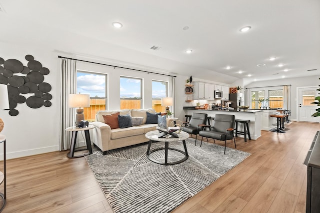 living area featuring light wood-style flooring, recessed lighting, and baseboards