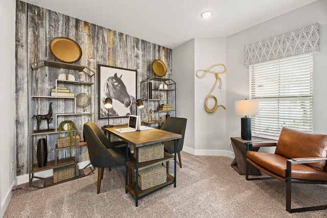 office featuring an accent wall, baseboards, and carpet flooring