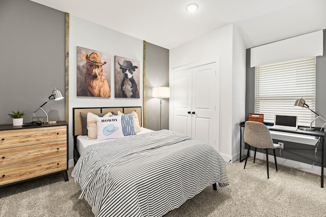 carpeted bedroom with a closet and a desk