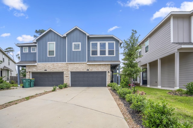 view of front of house with board and batten siding, concrete driveway, a garage, and stone siding
