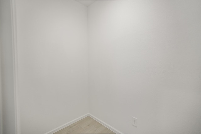 empty room with baseboards and light wood-style flooring