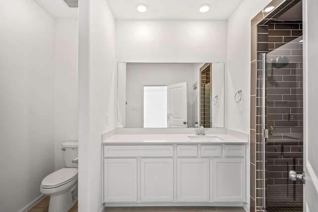 bathroom with a shower stall, vanity, and toilet