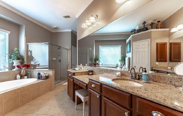 full bath with healthy amount of natural light, tile patterned flooring, a shower stall, a garden tub, and crown molding