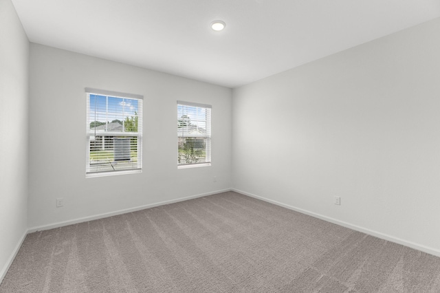 empty room with carpet flooring, baseboards, and recessed lighting