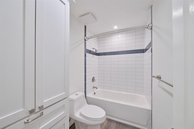 bathroom with toilet, wood finished floors, and shower / bathtub combination
