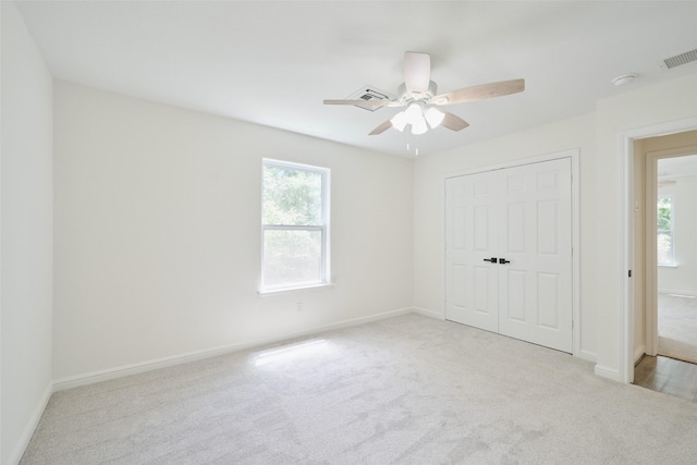 unfurnished bedroom featuring carpet, multiple windows, and baseboards