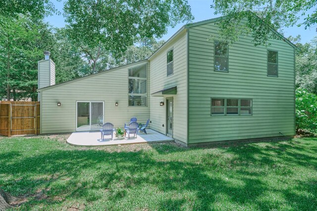 rear view of property featuring a patio and a chimney